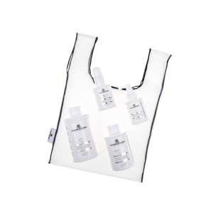 White tote bag with black trim holding five white skincare bottles inside.